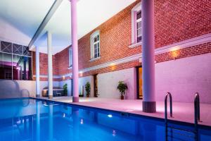 a swimming pool in front of a brick building at Hotel Hugo Business & Spa in Kędzierzyn-Koźle