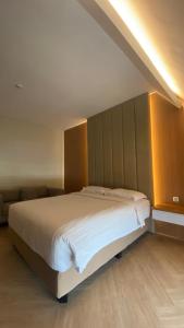 a bedroom with a large white bed in a room at Adotel in Jakarta