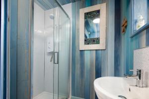 y baño con ducha acristalada y lavamanos. en Berrington Beach Hut, en Berwick-Upon-Tweed