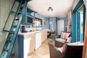 a kitchen with blue walls and a ladder in a room at Berrington Beach Hut in Berwick-Upon-Tweed +15 photos