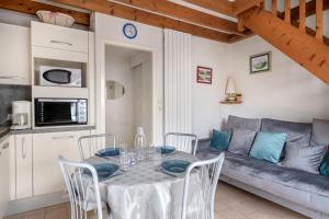 a living room with a table and a couch at Vacances familiales dans cette maison à Pornichet in Pornichet +9 photos