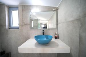 uma casa de banho com uma grande tigela azul num lavatório em Aiolos Executive Suite em Galatás