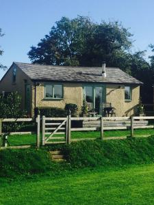 a house with a wooden fence in front of it at The Stable with cosy logburner in Wrexham