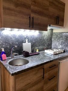 a kitchen with a sink and a counter top at Safir Pansiyon in Cıralı