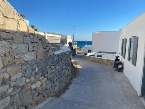 a stone wall next to a building and a street at Sea and Sun beach house at Platis Gialos in Platis Gialos