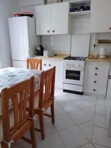 a kitchen with white appliances and a table and chairs at Éva Vendégház in Tata