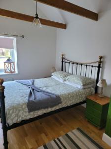 Schlafzimmer mit einem Bett, einem Tisch und einem Fenster in der Unterkunft Beautiful barn with private log fired hot tub in Maidstone