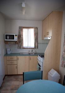 a small kitchen with a sink and a microwave at Strayleaves Caravan Park in Shepparton
