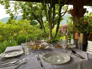 una mesa con platos de comida y copas de vino. en Mala Kmetija, en Slovenske Konjice
