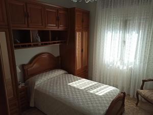比拉諾瓦德亞羅薩的住宿－Alquileres Delfina，一间卧室设有一张床和一个窗口