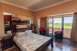 a bedroom with a bed and a large window at Dolphin Dance Lodge in Port Elizabeth