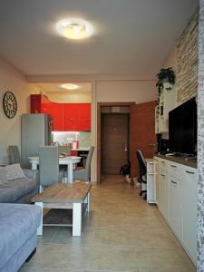 a living room with a couch and a kitchen with a table at Charming and Luxurious Flat with Large Terrace in Herceg-Novi