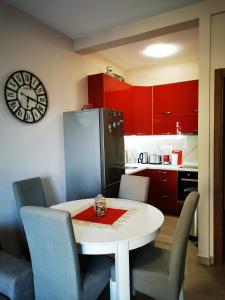 una cocina con una mesa blanca con sillas y un reloj en Charming and Luxurious Flat with Large Terrace, en Herceg-Novi