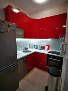 una cocina con armarios rojos y fregadero en Charming and Luxurious Flat with Large Terrace, en Herceg-Novi