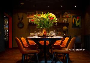 a table in a restaurant with a vase of flowers at Living Hotel Prinzessin Elisabeth in Munich