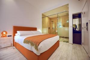 a bedroom with a large bed and a bathroom at Quaint Boutique Hotel Xewkija in Xewkija