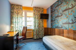 杜塞道夫的住宿－Hotel Arosa Düsseldorf Oberkassel，酒店客房设有一张床、一张书桌和一台电视机。