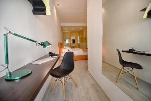 a room with a desk and two chairs and a bed at Quaint Boutique Hotel Xewkija in Xewkija