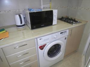 a kitchen with a microwave and a washing machine at Modern Apartment in Chişinău