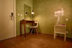 a room with a desk and a chair and a lamp at Quaint Boutique Hotel Xewkija in Xewkija