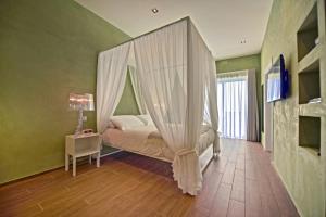a bedroom with a canopy bed and a table with a lamp at Quaint Boutique Hotel Xewkija in Xewkija
