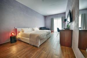 a bedroom with a bed and a television in it at Quaint Boutique Hotel Xewkija in Xewkija