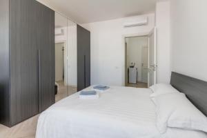 sypialnia z dużym białym łóżkiem z 2 książkami w obiekcie 12° Piano Torre Diamante - 67 w Mediolanie
