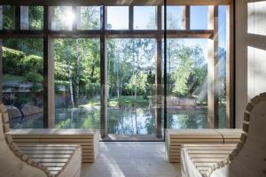 a large room with large windows and a view of a lake at Adler Spa Resort Dolomiti in Ortisei