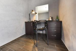 a chair in a room with a vanity and a mirror at Quaint Boutique Hotel Xewkija in Xewkija