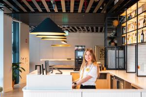 a woman standing at a counter in an office at Staycity Aparthotels Dublin City Quay in Dublin