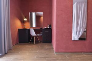 a room with a desk and a mirror on a pink wall at Quaint Boutique Hotel Xewkija in Xewkija
