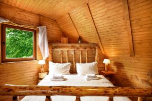 1 dormitorio con 1 cama en una cabaña de madera en Etno house Molendini en Rakovica