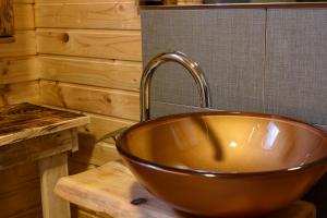 a copper bowl sink in a wooden bathroom at Etno house Molendini in Rakovica +15 photos