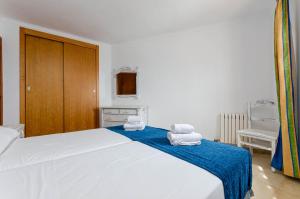 a bedroom with a large white bed with towels on it at Sol y Mar Apartments in Cala Bona