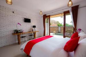 塞隆貝拉納克的住宿－Surya Lombok Accommodation，卧室配有带红色枕头的大型白色床