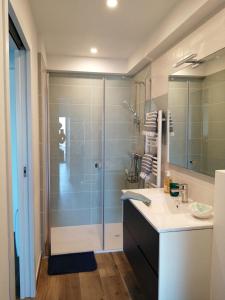 a bathroom with a glass shower and a sink at L'Échappée Bleue, vue mer in Binic