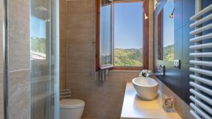 a bathroom with a sink and a toilet and a window at Villa Dolphin 10, Emma Villas in Massarosa +30 photos