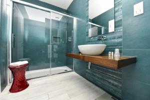 a bathroom with a sink and a glass shower at Quaint Boutique Hotel Xewkija in Xewkija