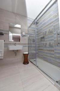a bathroom with a glass shower and a sink at Quaint Boutique Hotel Xewkija in Xewkija