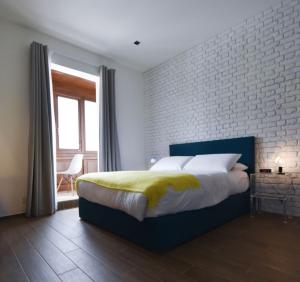 a bedroom with a bed and a brick wall at Quaint Boutique Hotel Xewkija in Xewkija