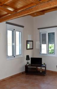 a living room with three windows and a table at S&G HOME in Platanias