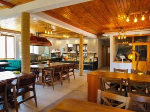 DemirciにあるKanyon park otel ve restaurantの木製の天井、テーブルと椅子のあるレストラン