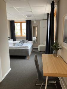 a hotel room with two beds and a table at Morlanda B&B in Ellös