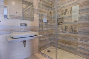 a bathroom with a glass shower with a sink at Quaint Boutique Hotel Xewkija in Xewkija