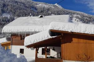 a snow covered roof of a house with a mountain at Chalet in Grosskirchheim in Carinthia with sauna in Großkirchheim