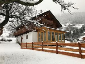 a house in the snow with a fence at Chalet in Grosskirchheim in Carinthia with sauna in Großkirchheim