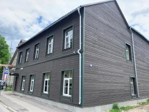 a black building with white windows on a street at Delta 6 two big beds in Tartu