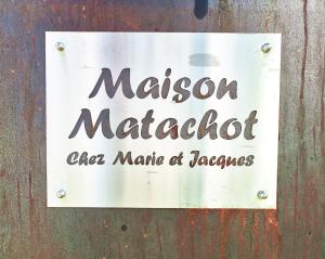 um sinal para um restaurante numa parede de madeira em Maison Matachot em Orthez