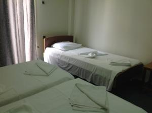 Morfeas Hotel في خالكيذا: سريرين في غرفة صغيرة مع سريرين sidx sidx
