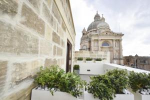 a view from the balcony of a building with potted plants at Quaint Boutique Hotel Xewkija in Xewkija +27 photos